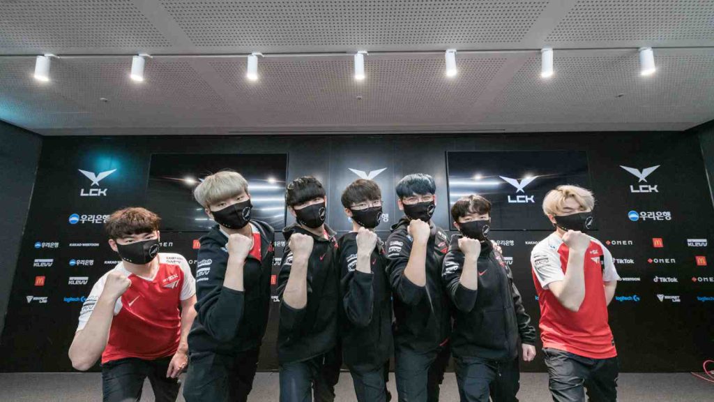 T1 roster pose with their arms and fist after winning LCK 2021 Regional Finals to qualify for Worlds