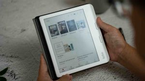 Hands holding kobo libra color e-reader, a digital book reader